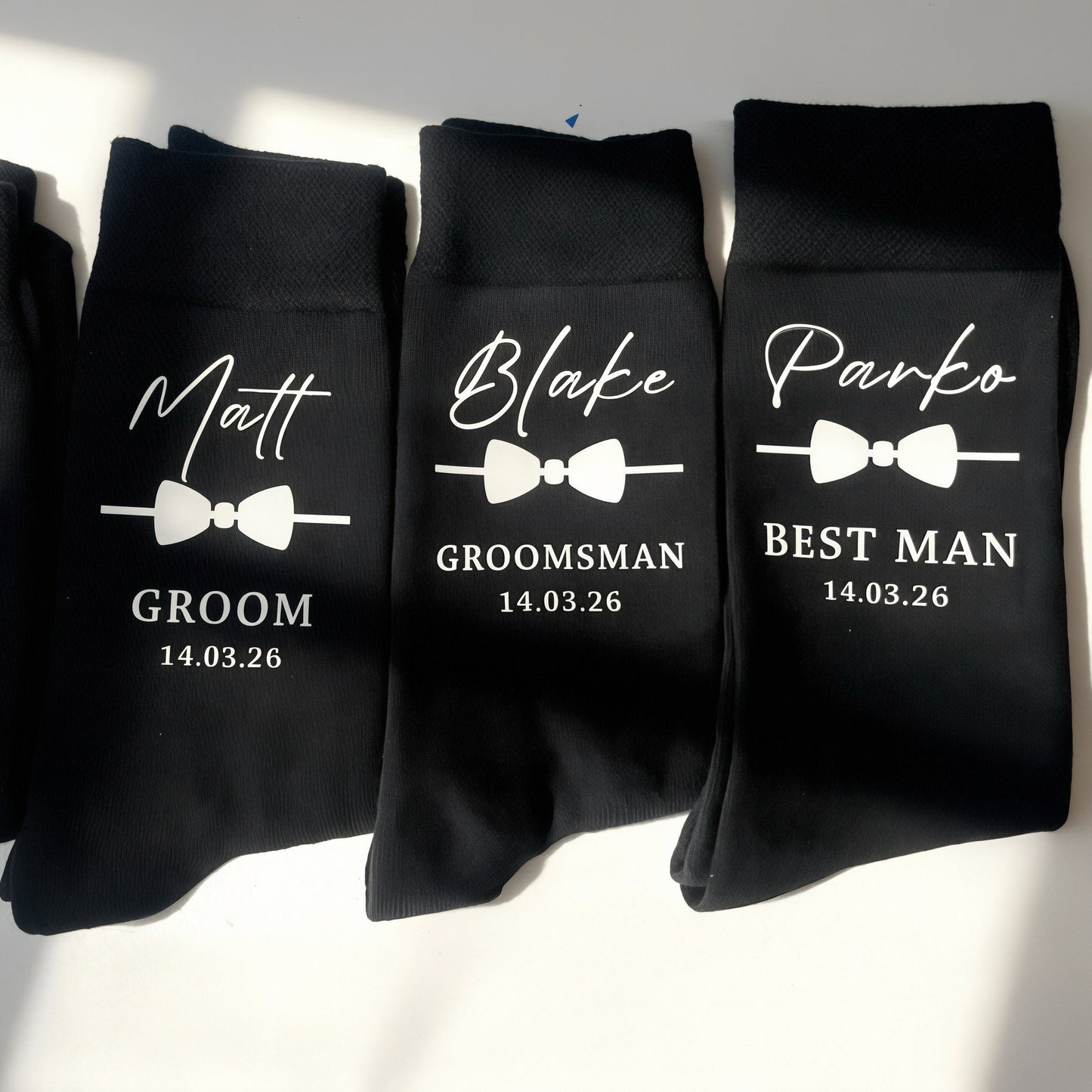 Four black socks with personalized text on a white background