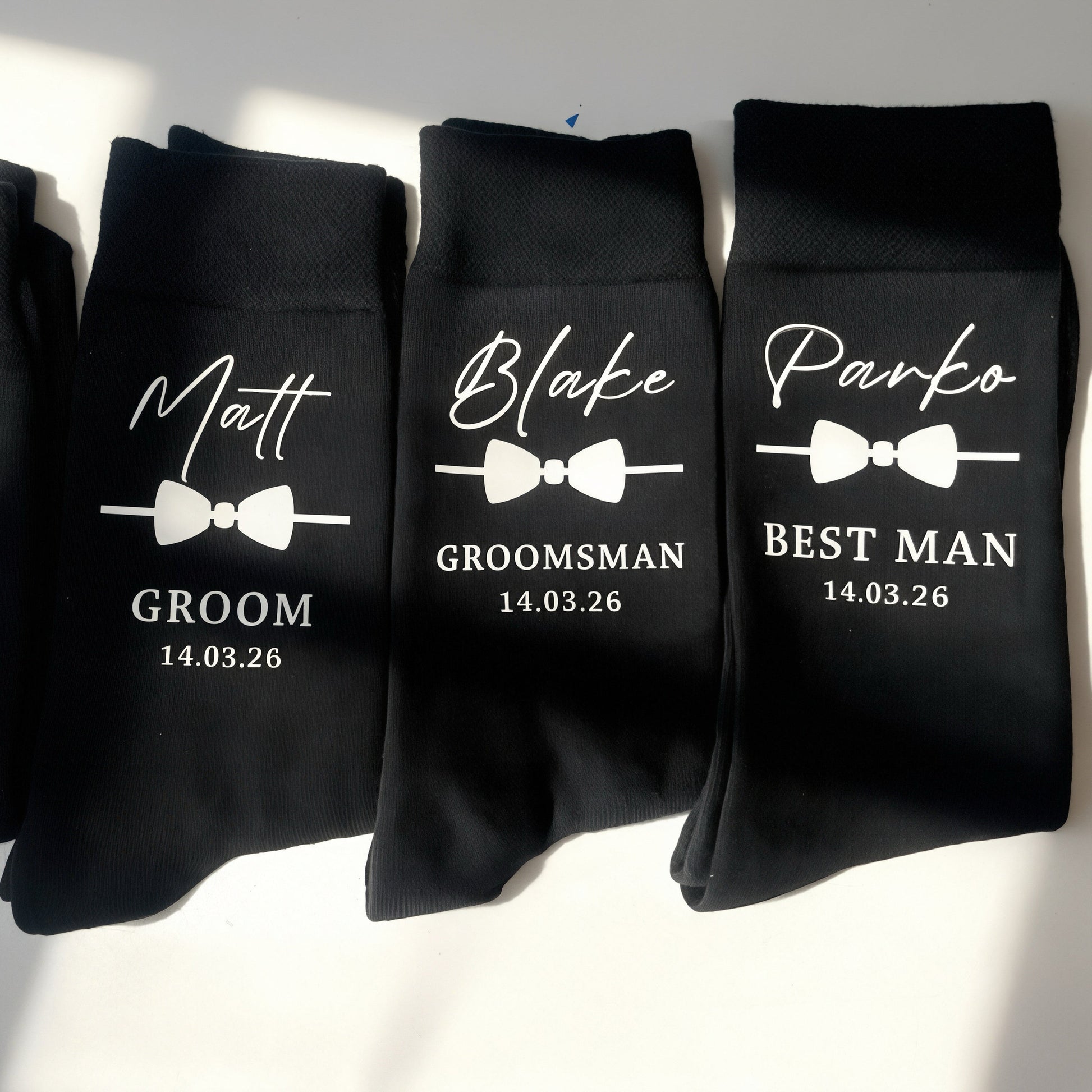 Four black socks with personalized text on a white background