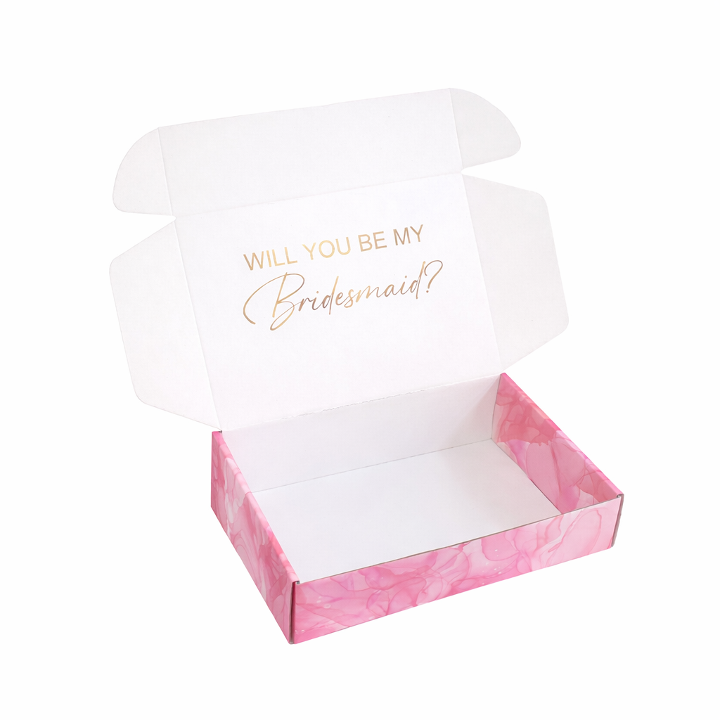 Open box with pink marble design and white interior, containing a card asking 'Will you be my bridesmaid?'